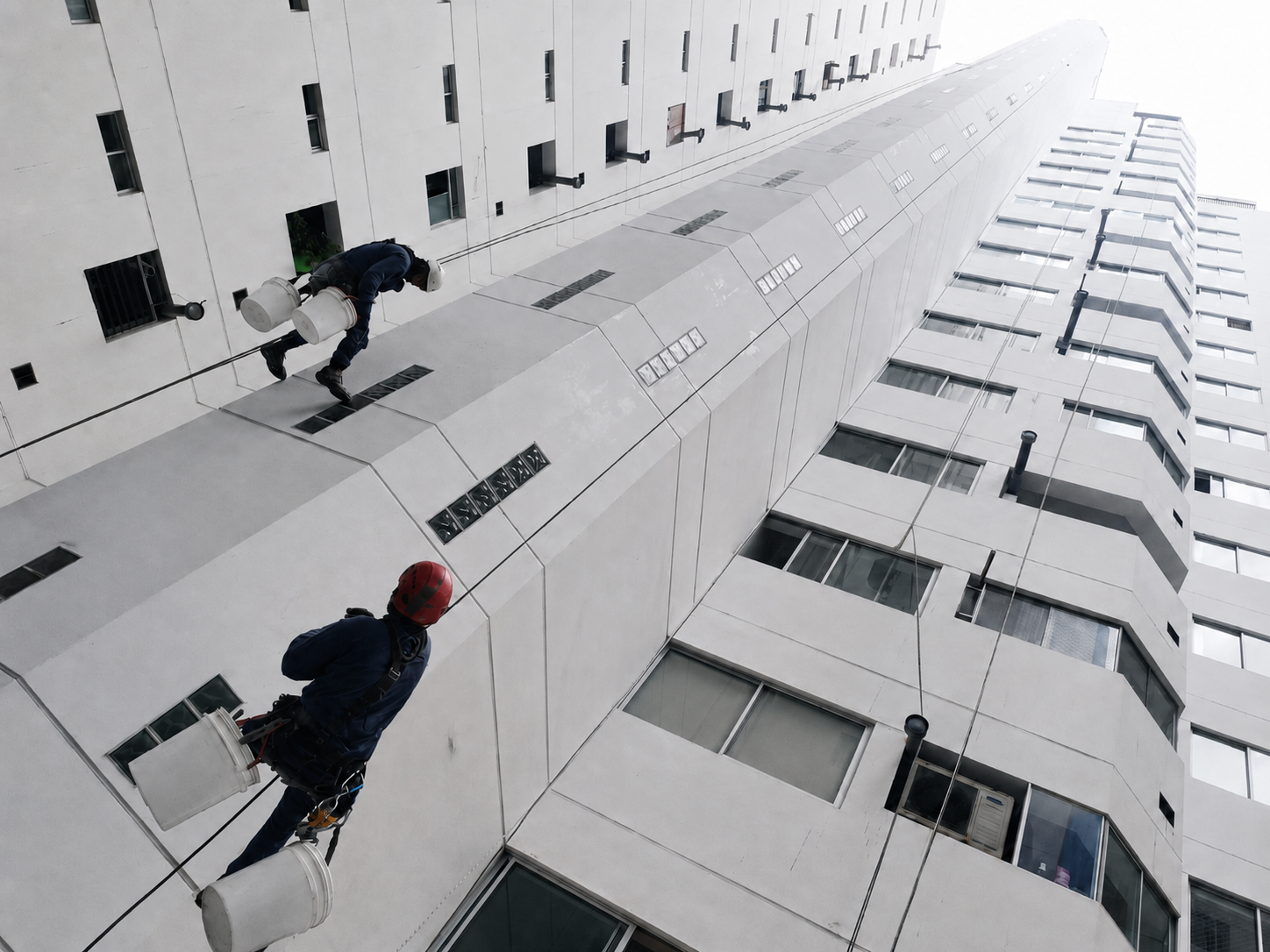 Trabajo de pintado en altura sobre la fachada del edificio